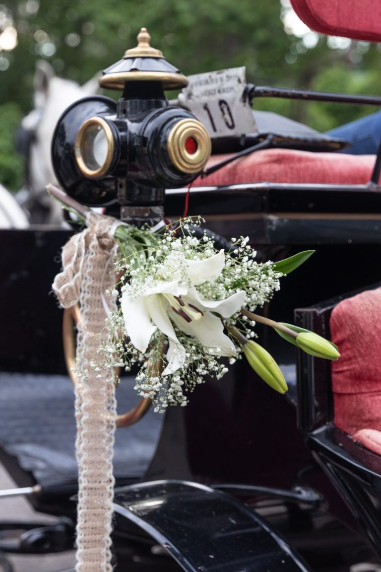 Ramo de flores blancas decorando un carruaje tirado por caballos. reportaje de bodas en Córdoba
